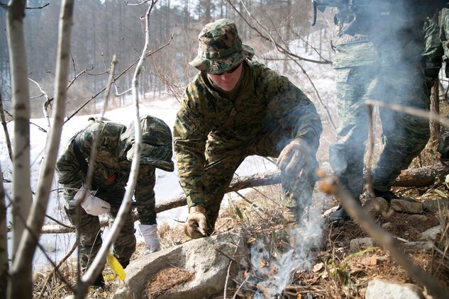 U.S. Marine Staff Sgt. Scott E. Brose, a Gold Beach, Oregon, native, tends to a fire alongside Republic of Korea Marines during Korean Marine Exchange Program 15-4 Feb. 4 at the Pyeongchang Winter Training Facility, Pyeongchang, Republic of Korea. Survival skills such as knowing how to find food and clean water and how to build fires and shelters are essential skills in nearly every environment, so this training allows the Marines to be more proficient at what they do, according to U.S. Marine Sgt. Joseph K. Blankenship. KMEP familiarizes U.S. Marines with the Korean Peninsula and builds upon an existing strong relationship between ROK and U.S. Marines. Brose is a fire support man with Company L, 3rd Battalion, 3rd Marine Regiment, currently assigned to 4th Marine Regiment, 3rd Marine Division, III Marine Expeditionary Force under the unit deployment program. The ROK Marines are with 1st Reconnaissance Battalion, 1st ROK Marine Division. 