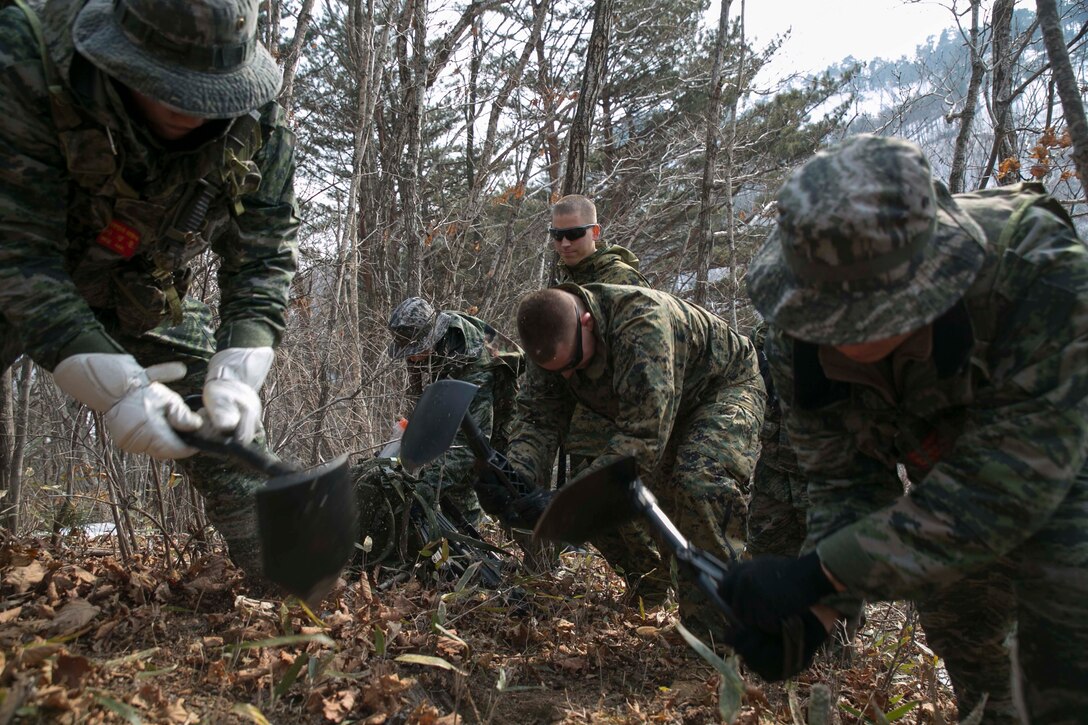 U.S. Marine Cpl. Alex S. Rankin, center, digs a hiding position alongside Republic of Korea Marines during Korean Marine Exchange Program 15-4 Feb. 4 at the Pyeongchang Winter Training Facility, Pyeongchang, Republic of Korea. The ROK recon Marines specialize in stealth and scouting, so this training teaches the Marines how to survive without getting caught and still accomplishing the mission. This exercise highlights the two countries’ combined commitment to the defense of the ROK and peace and security in the region. Rankin, a Secane, Pennsylvania, native, is an intelligence specialist with Company L, 3rd Battalion, 3rd Marine Regiment, currently assigned to 4th Marine Regiment, 3rd Marine Division, III Marine Expeditionary Force under the unit deployment program. The ROK Marines are with 1st Reconnaissance Battalion, 1st ROK Marine Division.