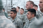 Tech. Sgt. Matthew Renteria and Senior Airman Michael Pineda listen to a brief before the obstacle course portion of the Texas Military Forces Best Warrior Competition at Camp Swift near Bastrop, Texas, Feb. 5, 2015. The event tests the mental and physical proficiencies of the participants through various challenges. Winners will continue to compete at a multi-state regional level. 