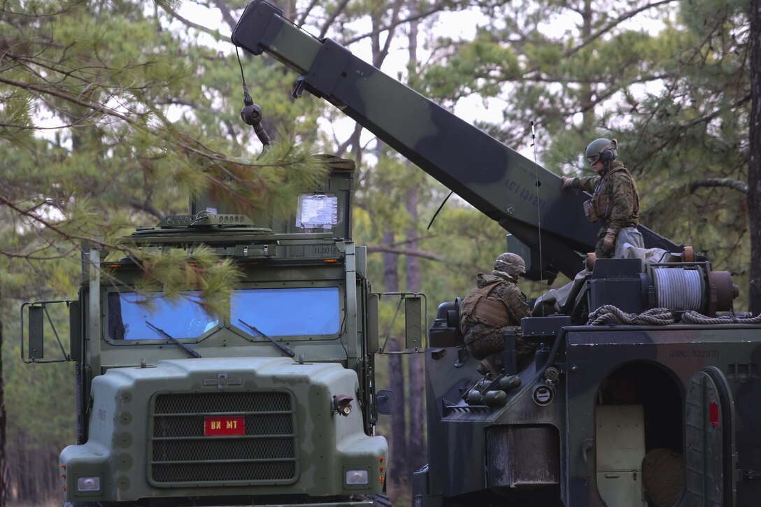 Marines with 2nd Assault Amphibian Battalion prepare to move a container from a Medium Tactical Vehicle Replacement with an Assault Amphibious Vehicle-mounted crane during a week-long field exercise aboard Camp Lejeune, N.C., Jan. 24, 2015. The exercise gave Marines new to the unit insight into how the battalion operates and the unit's role on deployments and in combat.