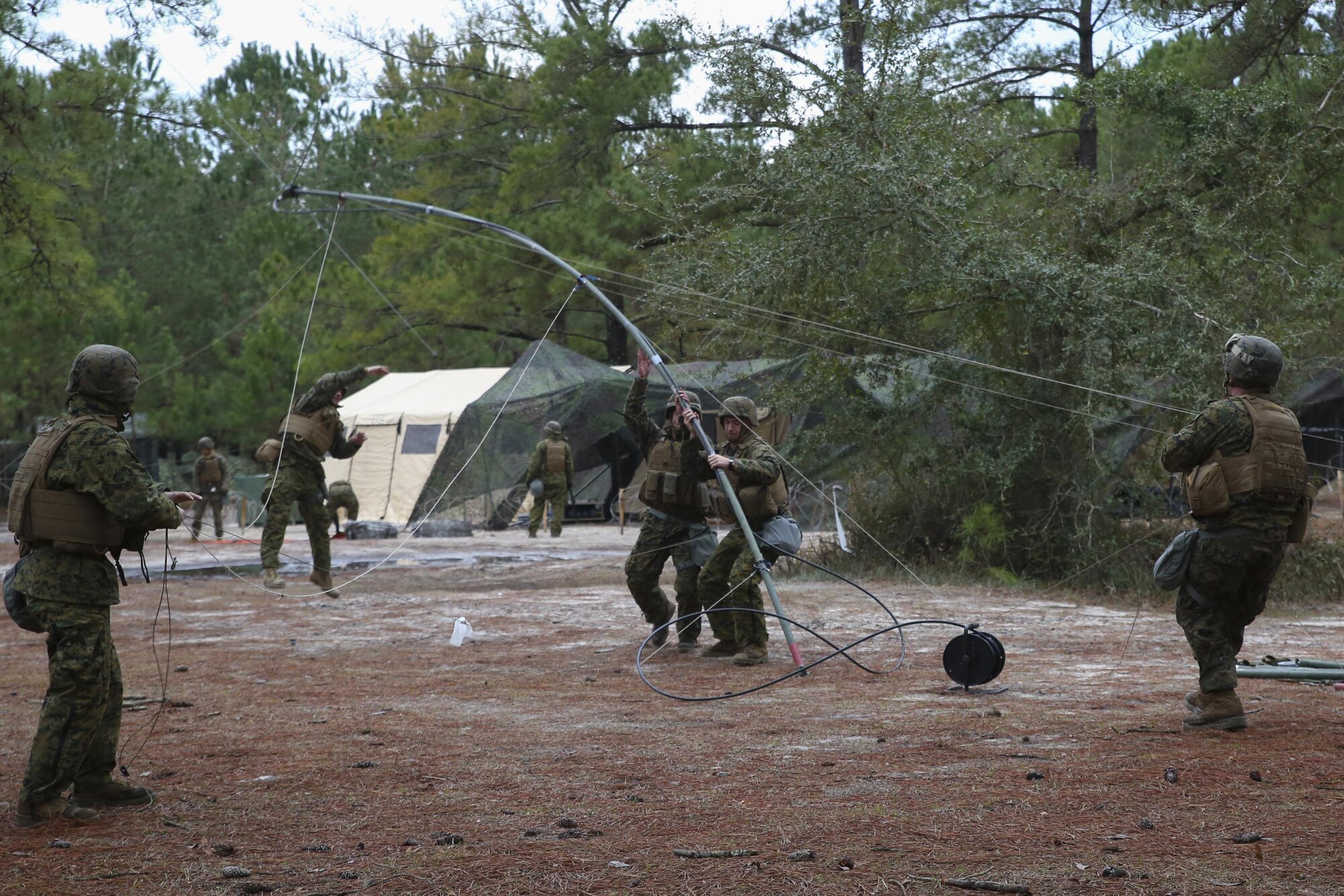 Marines with 2nd Assault Amphibian Battalion set up a communication antenna during a week-long field exercise aboard Camp Lejeune, N.C., Jan 24, 2015. The unit encountered obstacles to its operations with heavy rain, low temperatures and attacks by insurgent role-players, which made constant communication more difficult and more important.
