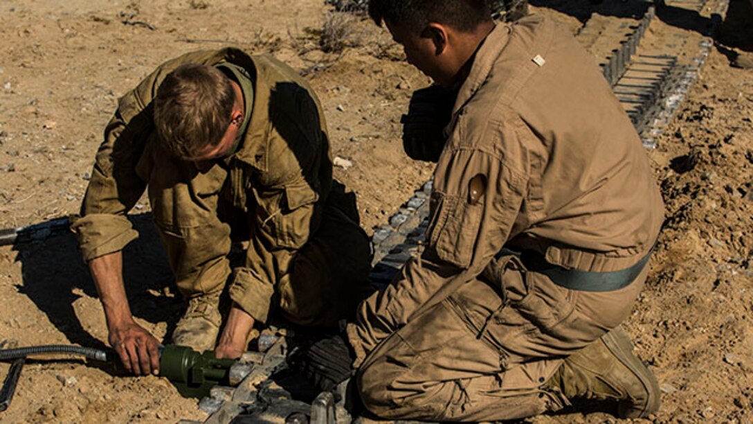 Lance Cpl. Nathan C. Tucker (left) and Lance Cpl. Chue Y. Yang replace blocks for a track on an M1A1 Abrams Main Battle Tank Jan. 1 at Marine Air Ground Combat Center Twentynine Palms as part of Integrated Training Exercise 2-15. Tucker and Yang work to finish pre-mission maintenance the night before the Tank Mechanized Assault Course. The TMAC involves multiple elements of the Marine Air-Ground Task Force to accomplish an assault. Tucker, a Hamilton, Ohio, native, and Yang, a St. Paul, Minnesota, native are tank crewmen, both with  Company D, 1st Tank Battalion, 1st Marine Division, I Marine Expeditionary Force. (U.S. Marine Corps photo by Lance Cpl. William Hester)