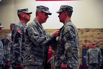 Maj. Gen. Donald Dunbar, the adjutant general of Wisconsin, presents the Purple Heart to Spc. Alexander Zerbst, a Wisconsin Army National Guard Soldier from Oconomowoc, Wis., at Richards Street Armory in Milwaukee Feb. 8, 2015. Zerbst received the medal after being injured in an improvised explosive device attack in Iraq in 2007. 