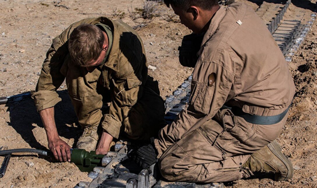 Lance Cpl. Nathan C. Tucker (left) and Lance Cpl. Chue Y. Yang replace blocks for a track on an M1A1 Abrams Main Battle Tank Jan. 1 at Marine Air Ground Combat Center Twentynine Palms as part of Integrated Training Exercise 2-15. Tucker and Yang work to finish pre-mission maintenance the night before the Tank Mechanized Assault Course. The TMAC involves multiple elements of the Marine Air-Ground Task Force to accomplish an assault. Tucker, a Hamilton, Ohio native, and Yang, a St. Paul, Minnesota native are tank crewmen, both with  Company D, 1st Tank Battalion, 1st Marine Division, I Marine Expeditionary Force. (U.S. Marine Corps photo by Lance Cpl. William Hester)