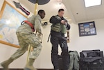 Senior Airman Stephen Teamer, assigned to the 3rd Aircraft Maintenance Squadron, rushes to an aircraft hangar as Air Force 1st Lt. Daniel Harp, an F-22 Raptor pilot assigned to the 525th Fighter Squadron, suits up at the Combat Alert Center on Joint Base Elmendorf-Richardson Jan. 23. Within minutes of an alert, Airmen in the CAC spring into action and launch F-22 Raptors to intercept aircraft entering U.S. airspace or potential airborne threats. (U.S. Air Force photo/Justin Connaher)
