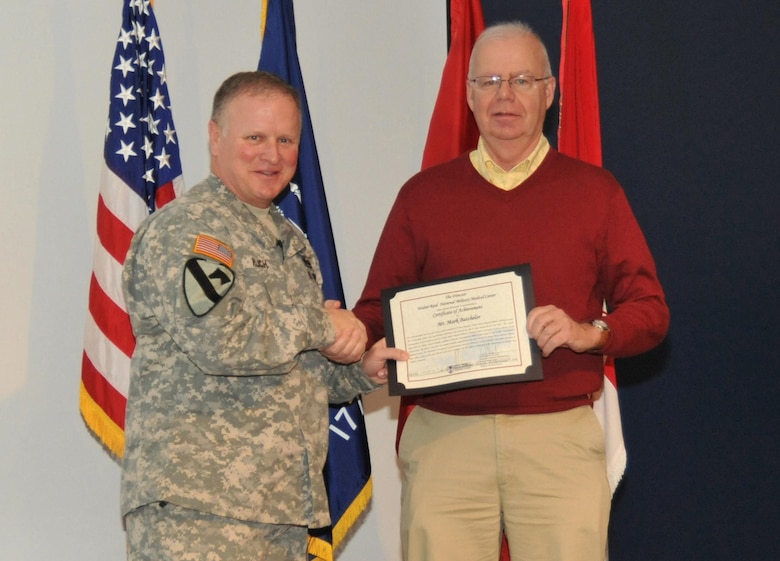 During the Jan. 23 Town Hall, Huntsville Center Commander Col. Robert J. Ruch presents Mark Batchelor with a Certificate of Achievement on behalf of Brig. Gen. Jeffrey Clark, Director of the Walter Reed National Military Medical Center.