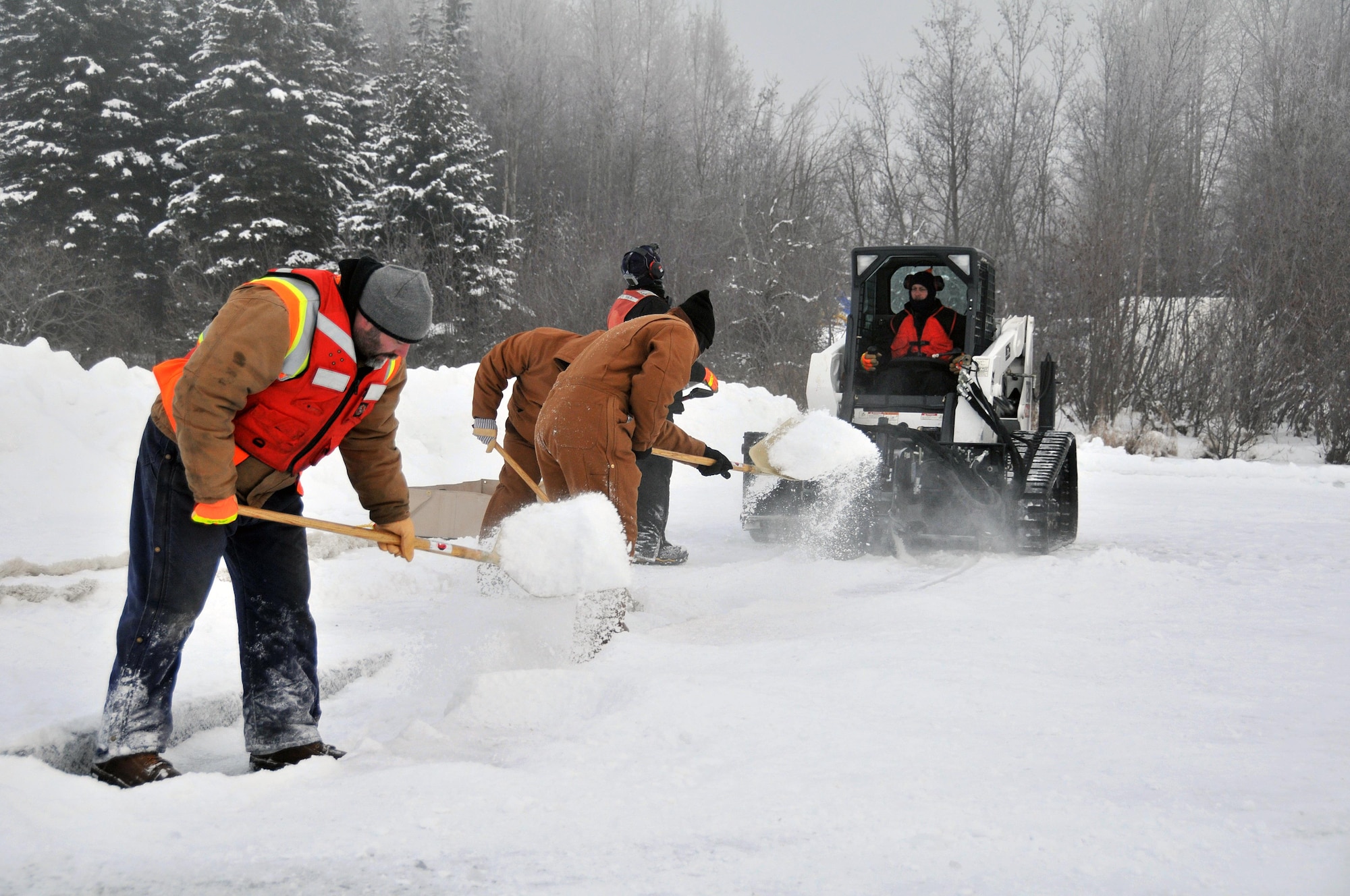 Members of the Alaska Department of Environmental Conservation, 611th Civil Engineer Squadron, and U.S. Navy Supervisor of Salvage and Diving set up the rope mop skimmer during an Arctic oil spill response exercise Feb. 4, 2015, in Alaska. A trench is dug a certain depth in the ice and holes are drilled to allow the oil/product to rise up into the trench to be collected. The skimmer rotates through the trench collecting the oil and sends it to a holding tank. The units participated in the exercise to learn Arctic spill response tactics and techniques. (U.S. Air Force photo/Tech. Sgt. John Gordinier)