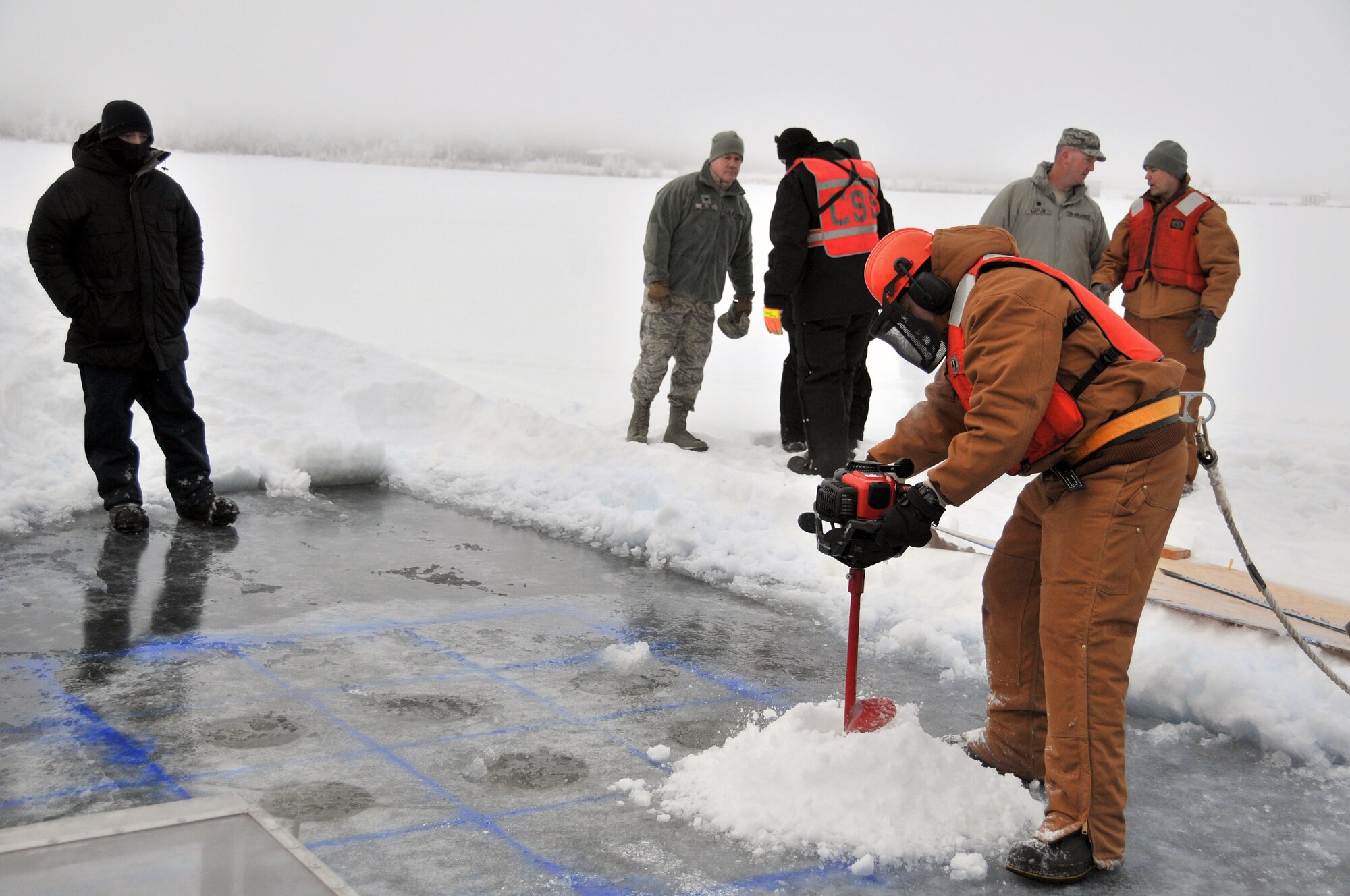 Tech. Sgt. Douglas Ward drills holes for blocks to be cut and removed during an Arctic oil spill response exercise Feb. 4, 2015, in Alaska. The removed blocks will open up a trench to deploy accumulation equipment to clean up a simulated spill. Members of the Alaska Department of Environmental Conservation, 611th Civil Engineer Squadron, U.S. Navy Supervisor of Salvage and Diving, and U.S. Coast Guardsmen participated in the exercise to learn Arctic spill response tactics and techniques. Ward is the 611th CES Heating, Ventilation, and Air Conditioning Shop NCO in charge (U.S. Air Force photo/Tech. Sgt. John Gordinier)