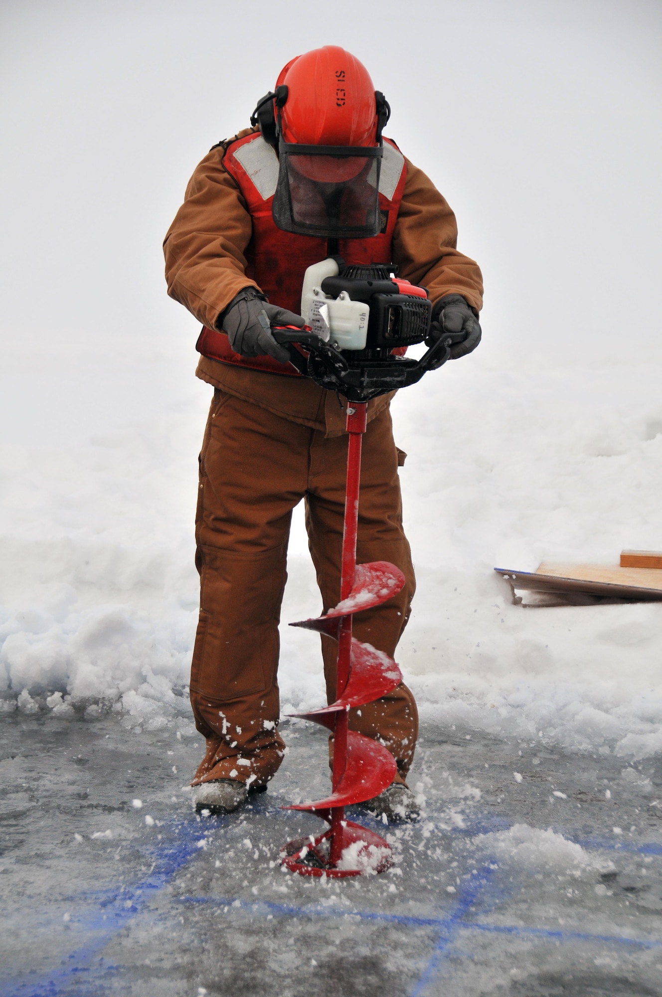 Senior Master Sgt. Gene Geren drills holes for blocks to be cut and removed during an Arctic oil spill response exercise Feb. 4, 2015, in Alaska. The removed blocks will open up a trench to deploy accumulation equipment to clean up a simulated spill. Members of the Alaska Department of Environmental Conservation, 611th Civil Engineer Squadron, U.S. Navy Supervisor of Salvage and Diving, and U.S. Coast Guardsmen participated in the exercise to learn Arctic spill response tactics and techniques. Geren is the 11th Air Force first sergeant. (U.S. Air Force photo/Tech. Sgt. John Gordinier)