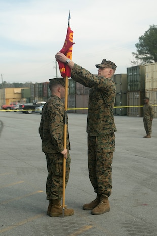 Capt. Keaton J. Thomas, right, Commanding Officer of Marine Air Ground Task Force Materiel Distribution Company, unfurls the guidon during the company’s activation ceremony, Feb. 9, 2015, aboard Camp Lejeune, North Carolina. The company has been created within 2nd Supply Battalion, Combat Logistics Regiment 25, 2nd Marine Logistics Group, to establish a proof of principle on the reorganization of intermediate supply and distribution capabilities in order to provide tailored capabilities to units deploying in support of II Marine Expeditionary Force. The mission of the MMDC is to provide general shipping and receiving services, consolidated distribution services and to maintain asset visibility to enhance throughput velocity and sustain operational tempo. (U.S. Marine Corps photo by Cpl. Elizabeth A. Case/Released)