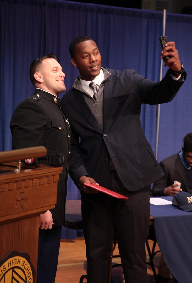 BUFFALO, NY – Canisius High School Crusaders tight end T. J. Wheatley takes a selfie with Marine Capt. Michael A. Kelly after receiving a certificate of appreciation during a signing ceremony at his high school, Feb. 4. Wheatley received the certificate signed by Maj. Gen. Mark Brilakis for playing in the Semper Fidelis All American Bowl this year. He earned the privilege to play in the game after his head coach nominated him earlier last year. Brilakis is the commanding general of Marine Corps Recruiting Command. Kelly is the operations officer for Marine Corps Recruiting Station Buffalo. (Official U.S. Marine Corps photo by Sgt. Christopher O’Quin/Released)