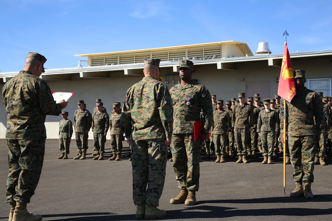 Sgt. Maj. Abel Leal, Headquarters Battalion Sergeant Major, reads an award citation for 1st Sgt. Frank Robinson, Company A First Sergeant, HQBN, aboard the Combat Center, Jan. 22, 2015. Robinson was awarded a Purple Heart and a Navy and Marine Corps Commendation Medal. (Official Marine Corps photo by Lance Cpl. Thomas Mudd/ Released)