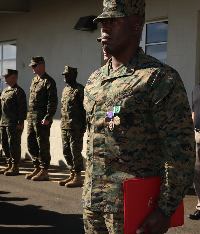 1st Sgt. Frank Robinson, Company A first sergeant, Headquarters Battalion, stands at attention after receiving a Purple Heart and a Navy Marine Corps Commendation Medal aboard the Combat Center, Jan. 22, 2015. (Official Marine Corps photo by Lance Cpl. Thomas Mudd/Released)