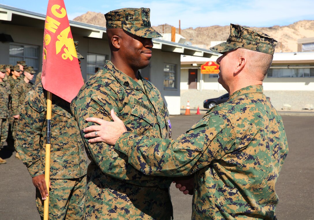 1st Sgt. Frank Robinson, Company A First Sergeant, Headquarters Battalion, shakes the hand of Lt. Col. Dennis Sanchez, HQBN Commanding Officer, aboard the Combat Center Jan. 22, 2015. Robinson was awarded a Purple Heart for wounds he sustained in Afghanistan, Aug. 10, 2014. (Official Marine Corps photo by Lance Cpl. Thomas Mudd/ Released)