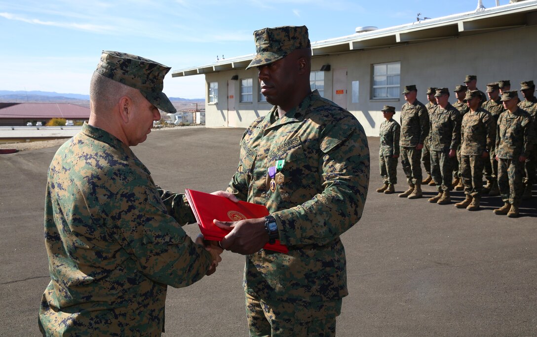 1st Sgt. Frank Robinson, Company A First Sergeant, Headquarters Battalion, shakes the hand of Lt. Col. Dennis Sanchez, HQBN Commanding Officer, aboard the Combat Center, after being pinned with a Purple Heart and a Navy and Marine Corps Commendation Medal, Jan. 22, 2015. Marines from HQBN congratulated Robinson after the citation and awards were given. (Official Marine Corps photo by Lance Cpl. Thomas Mudd/Released)