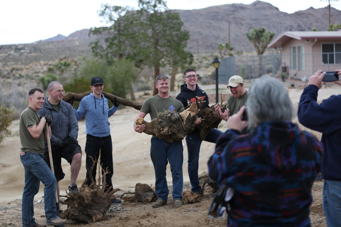 1st Tank Battalion Marines and sailors pose for a photo after helping remove a tree stump from Richard Krekemeyer’s, WWII veteran, native of Twentynine Palms, Calif., front yard during Reach Out Morongo Basin, Jan. 26, 2015. The event was a joint effort between 3rd Battalion, 11th Marine Regiment and 1st Tank Battalion to restore the homes of the elderly and handicapped. (Official Marine Corps photo by Lance Cpl. Medina Ayala-Lo/Released)