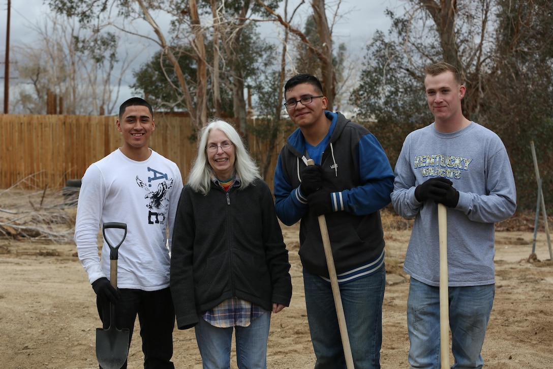 3rd Battalion, 11th Marine Regiment Marines pose with Janet Cole during Reach Out Morongo Basin, Jan. 26, 2015. The Marines were there to help Cole with anything she may have needed around the house as part of a larger effort to give back to the community. (Official Marine Corps photo by Lance Cpl. Medina Ayala-Lo/Released)