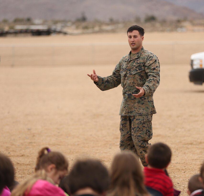 Sgt. Darren Westmoreland, military working dog handler, K-9 Unit, Provost Marshal’s Office, answers a question from a Joshua Tree Elementary School student about the Marine’s job as a MWD handler during a demonstration at the school, Jan. 29, 2015. The MWD handlers answered questions that students and teachers had about the MWDs. (Official Marine Corps Photo by Lance Cpl. Julio McGraw/Released)