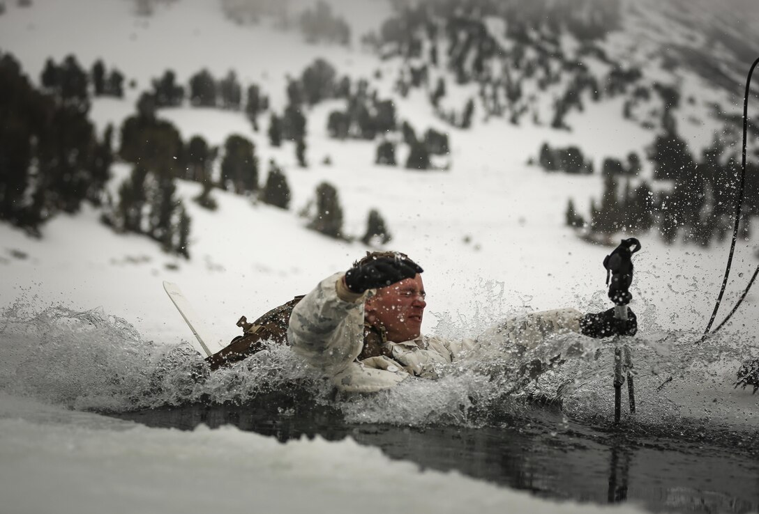 Cpl. David McKenna, Winter Mountain Leaders Course 1-15, student, 1st Battalion, 3rd Marine Regiment, plunges into freezing water during an Ice-Breaker Drill as part of WMLC 1-15 at Levitt Lake, Marine Corps Mountain Warfare Training Center training area in Bridgeport, Calif., Jan. 30, 2015. Each Marine slid into the water on the skis with the five gallon weighted pack and a pair of ski poles. (Official Marine Corps photo by Cpl. Charles Santamaria/Released)