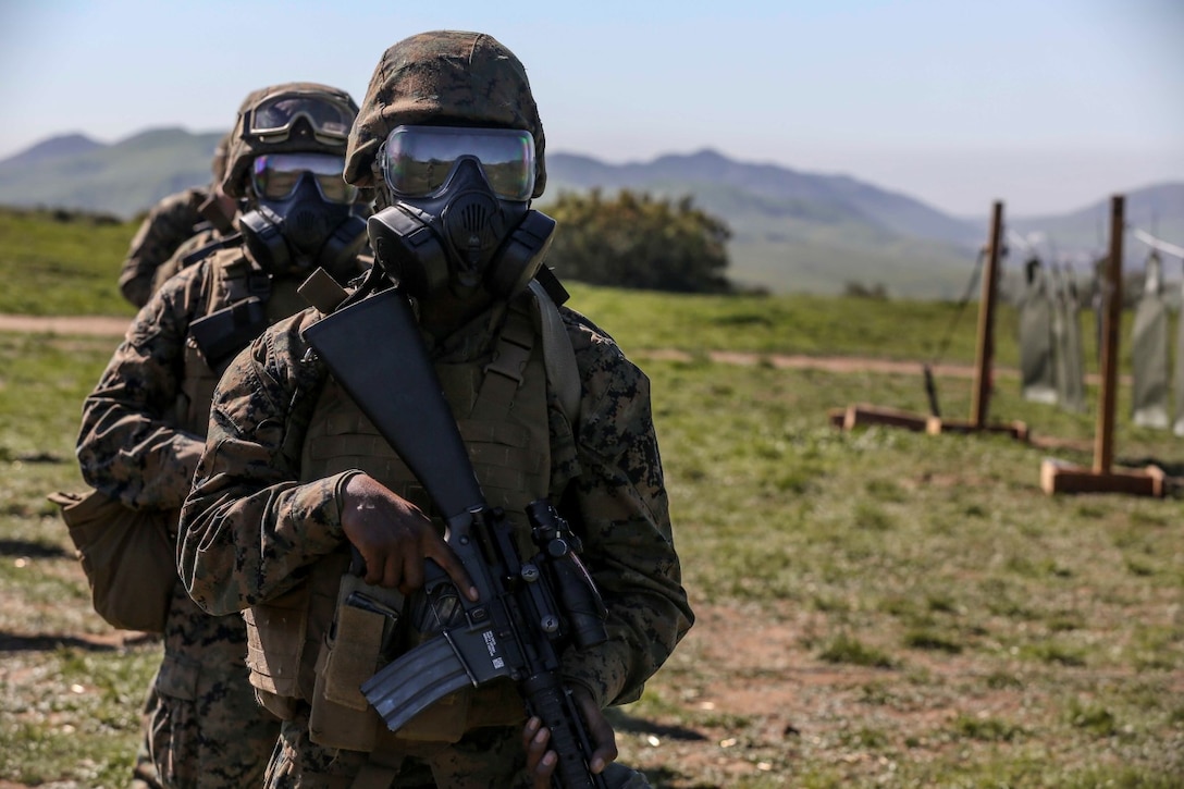 U.S. Marine Lance Cpl. Garnett Jackson prepares to engage targets while wearing a gas mask during combat marksmanship training aboard Camp Pendleton, Calif., Feb. 9, 2015. Jackson is a data specialist with Combat Logistics Battalion 15. The Marine Corps Combat Marksmanship Program is designed to keep Marines in a combat mindset.  As the logistics combat element for the15th MEU, CLB-15 is training to ensure readiness for any situation they may encounter during their upcoming deployment this spring. (U.S. Marine Corps photo by Cpl. Anna Albrecht/Released)