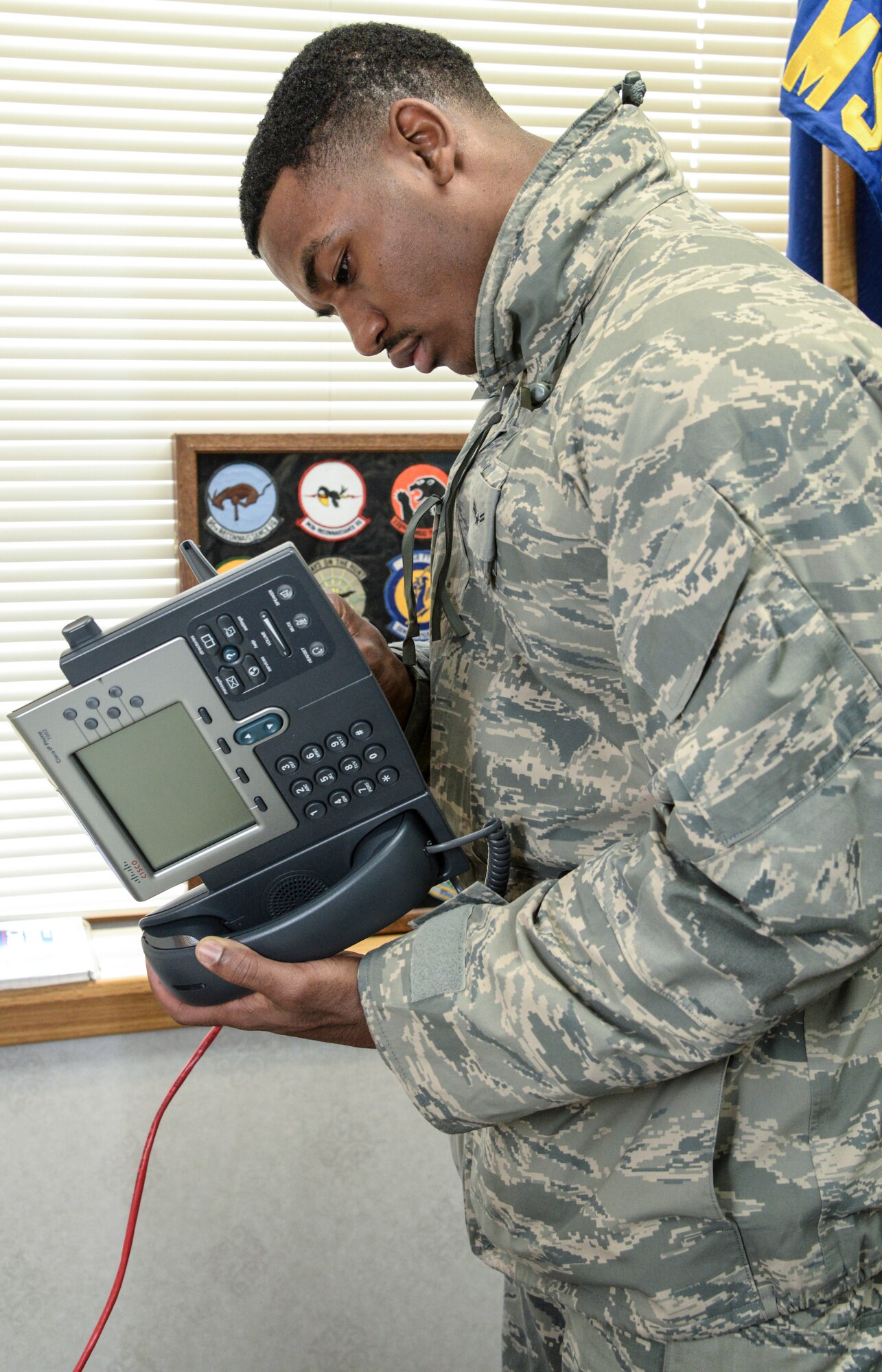 Airman 1st Class Byron Brown, a 51st Communications Squadron client systems technician, exams the wire connection of a phone Feb. 6, 2015, at Osan Air Base, Republic of Korea. The client systems technicians have a specific team who provides communication support for commanders and vice commanders on Osan. (U.S. Air Force photo by Senior Airman Matthew Lancaster)