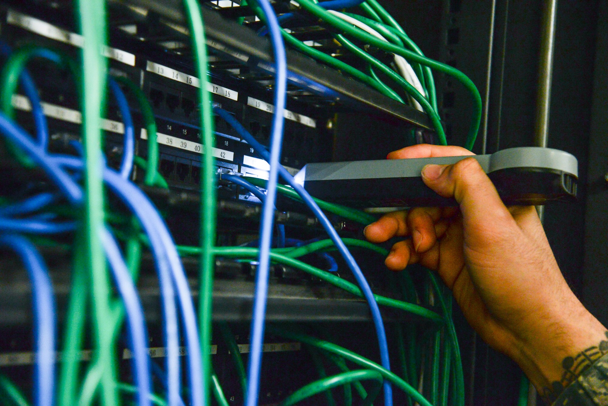 Senior Airman Tarek Salem, a 51st Communications Squadron client systems technician, searches for a specific computer port on a patch port panel Feb. 6, 2015, at Osan Air Base, Republic of Korea. Each port in every building is connected to a patch port panel in order to connect to the server switch. (U.S. Air Force photo by Senior Airman Matthew Lancaster)
