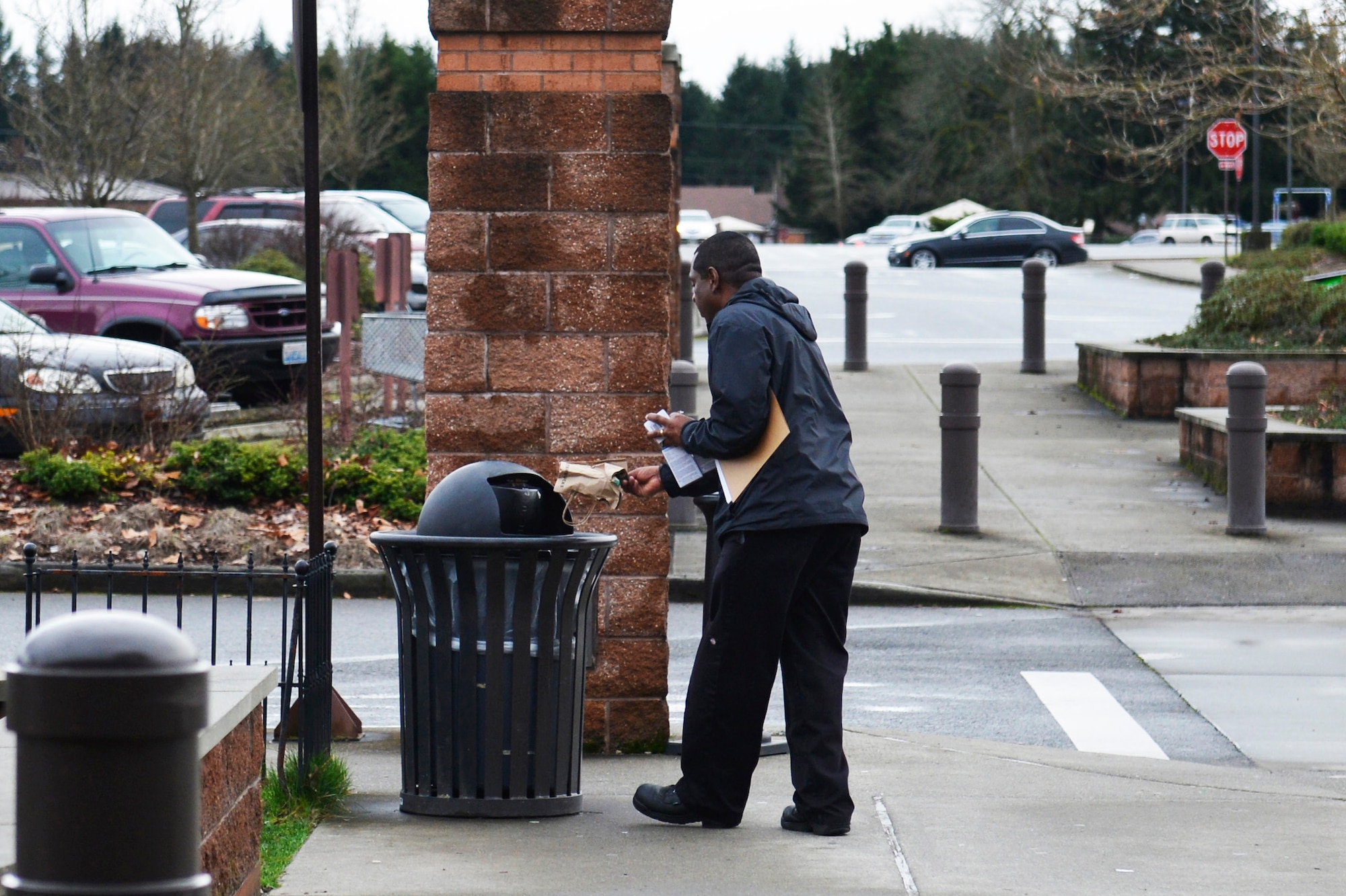 Gary Mosley, Joint Base Lewis-McChord Base Exchange services business technician, throws away a littered bag, Feb. 9, 2015, at JBLM, Wash. By taking the responsibility of base beautification into their own hands, McChord members can actively make a difference in their community.  (U.S. Air Force photo/Senior Airman Rebecca Blossom)