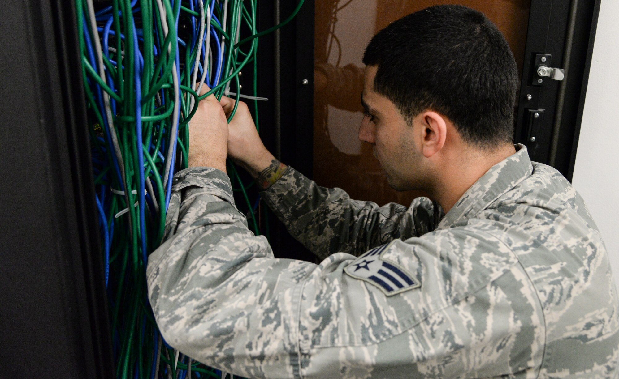 Senior Airman Tarek Salem, 51st Communications Squadron client systems technician, connects a computer port to the network server switch Feb. 6, 2015, at Osan Air Base, Republic of Korea. The sever switch is a piece of equipment that allows the computer ports the ability to connect to the Osan computer network. (U.S. Air Force photo by Senior Airman Matthew Lancaster)