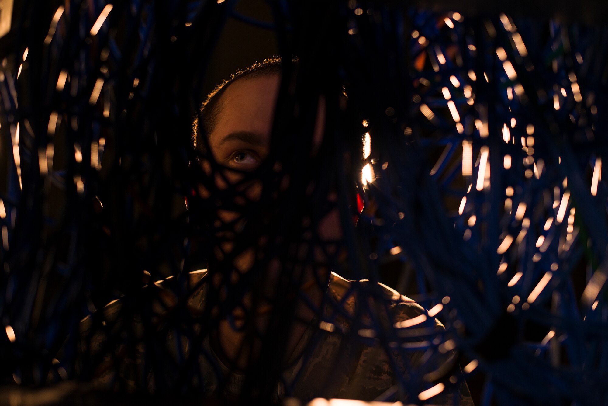 Senior Airman Neil Kenny, 51st Communications Squadron client systems technician, looks through wires into a switchboard Feb. 10, 2015, at Osan Air Base, Republic of Korea. Kenny is one of 34 CSTs who provide service for more than 7,000 customers on base.  (U.S. Air Force photo by Senior Airman Matthew Lancaster)