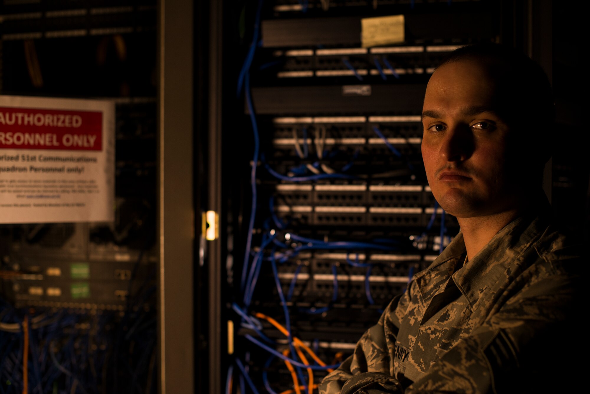Senior Airman Neil Kenny, 51st Communications Squadron client systems technician, stands in front of switchboards Feb. 10, 2015, at Osan Air Base, Republic of Korea. Kenny is one of 34 CSTs who provide service for more than 7,000 customers on base.  (U.S. Air Force photo by Senior Airman Matthew Lancaster)