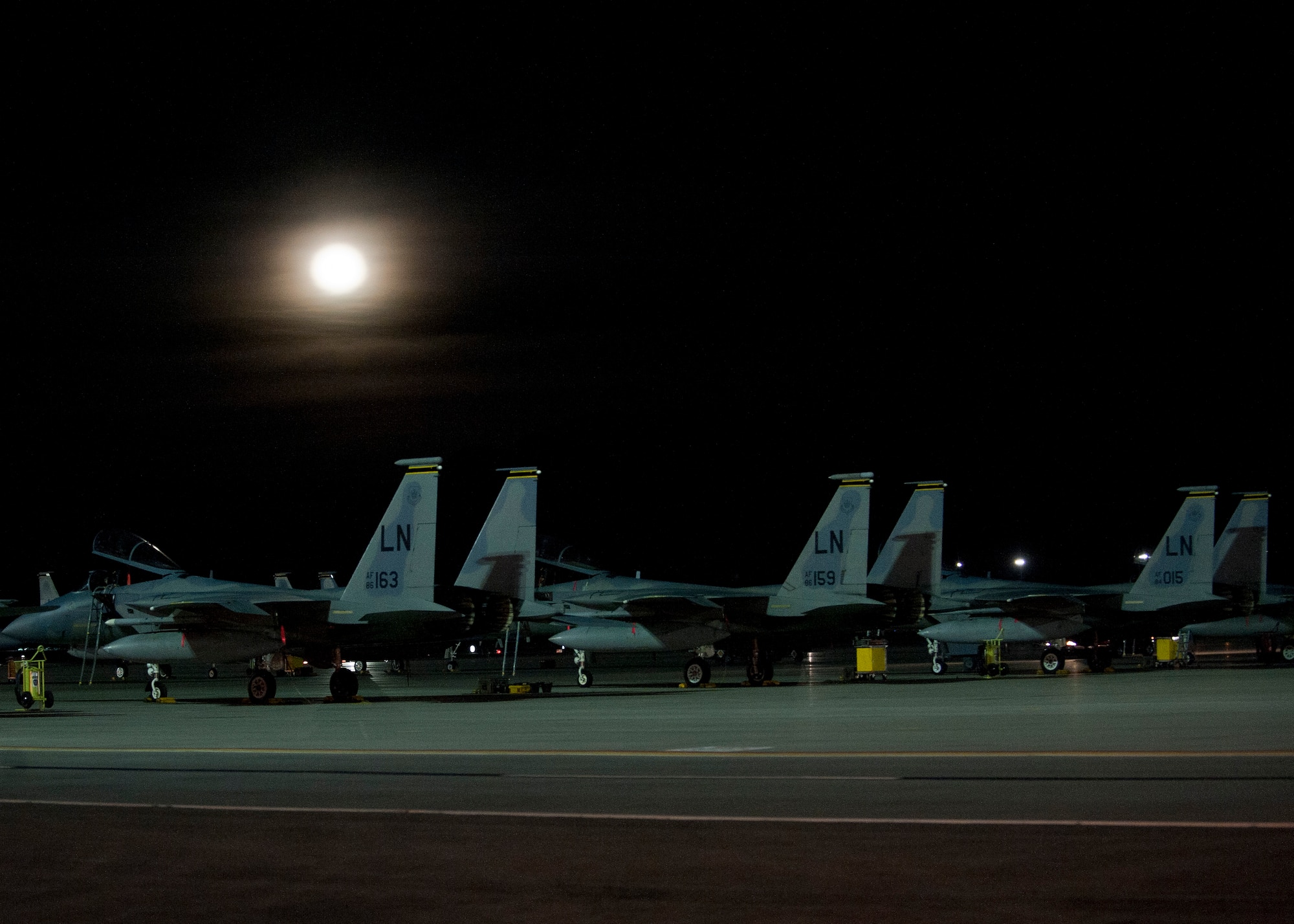 Three F-15 Eagles assigned to the 493rd Fighter Squadron, Royal Air Force Lakenheath, England, sit on the flightline under the moonlight during Red Flag 15-1 at Nellis Air Force Base, Nev., Feb. 4, 2015. Red Flag is a realistic combat training exercise involving the air, space and cyber forces of the U.S. and its allies, and is conducted on the vast bombing and gunnery ranges on the Nevada Test and Training Range during day and night operations. (U.S. Air Force photo by Staff Sgt. Siuta B. Ika)