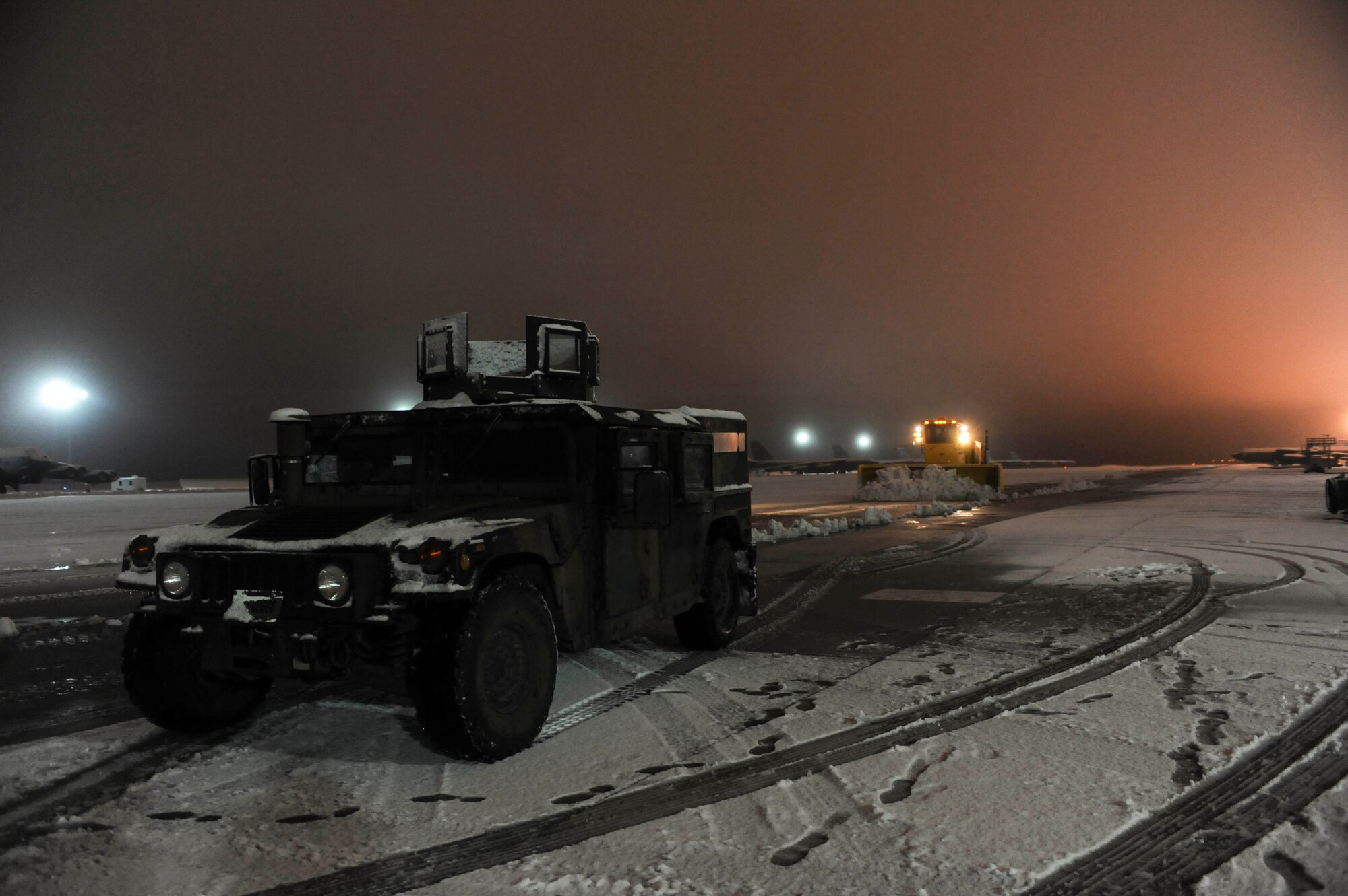 A Humvee waits for a snowplow to pass it before resuming its patrol of the flightline on Minot Air Force Base, N.D., Jan. 24, 2015. During the winter snowplows and brooms work day and night to ensure the flightline is ready to support taxiing and take off. (U.S. Air Force photo/Senior Airman Stephanie Morris)