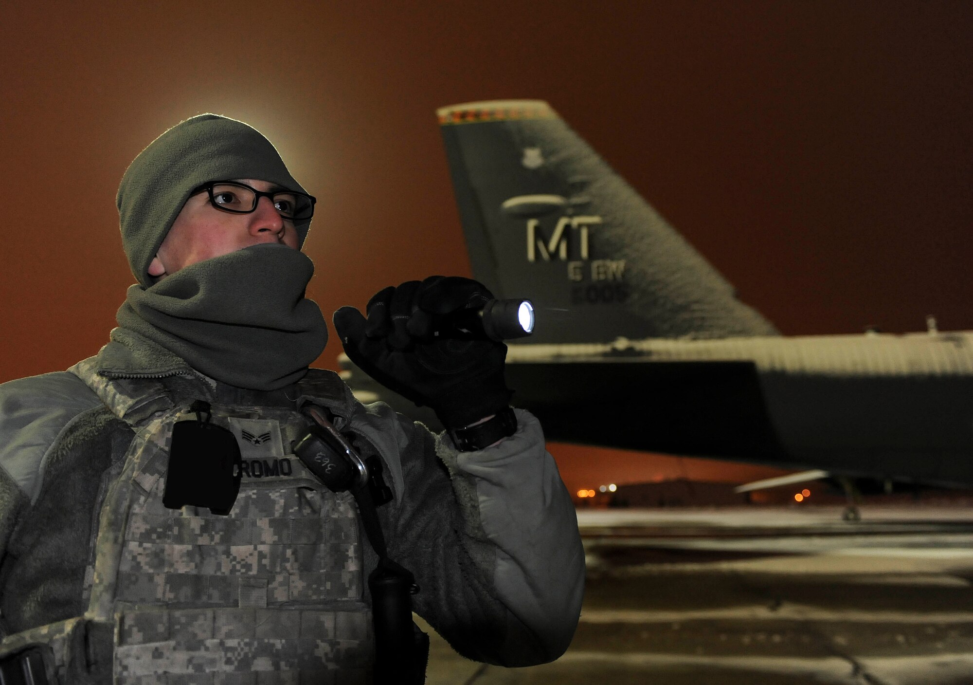 Senior Airman Sergio Romo, 5th Security Forces Squadron law enforcement patrolman, uses a flashlight to inspect the area around a B-52H Stratofortress on Minot Air Force Base, N.D., Jan. 24, 2015. Romo’s day begins at approximately 1 p.m. when he goes to the gym and by 3 p.m. he is preparing to head to work. When much of the base is preparing to go home, Romo and his teammates will not be leaving their posts until 7 a.m. the next morning. (U.S. Air Force photo/Senior Airman Stephanie Morris)