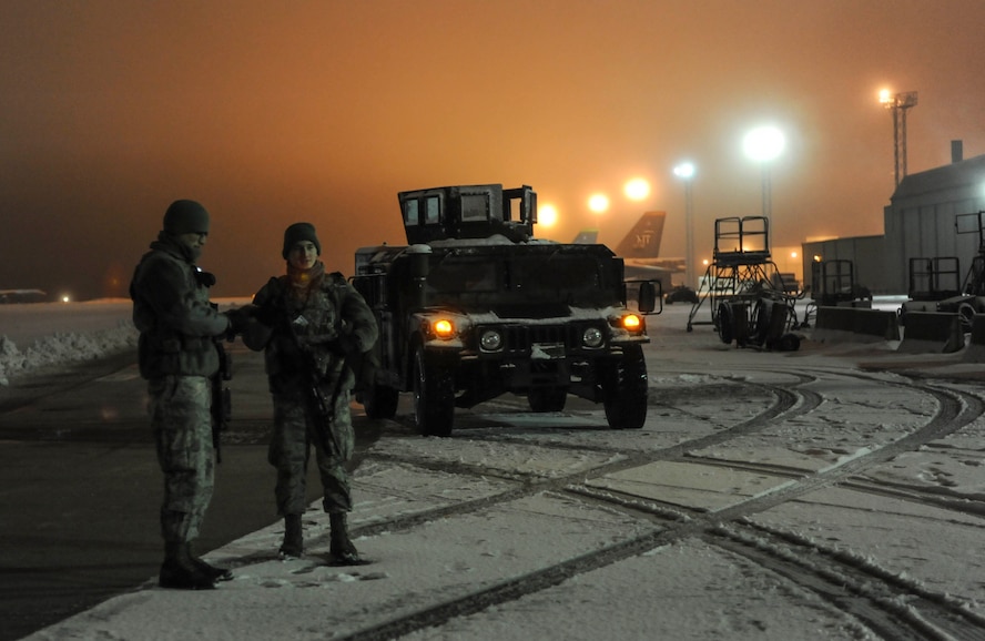 (left) Senior Airman Sergio Romo, 5th Security Forces Squadron law enforcement patrolman, and (right) Airman 1st Class Zane Crady, 5th SFS response force team member, prepare to inspect the area around a B-52H Stratofortress on Minot Air Force Base, N.D., Jan. 24, 2015. Airmen in Romo and Crady’s squadron are posted to several locations on base during the night including the weapons storage area, the front gate and the flightline. (U.S. Air Force photo/Senior Airman Stephanie Morris)