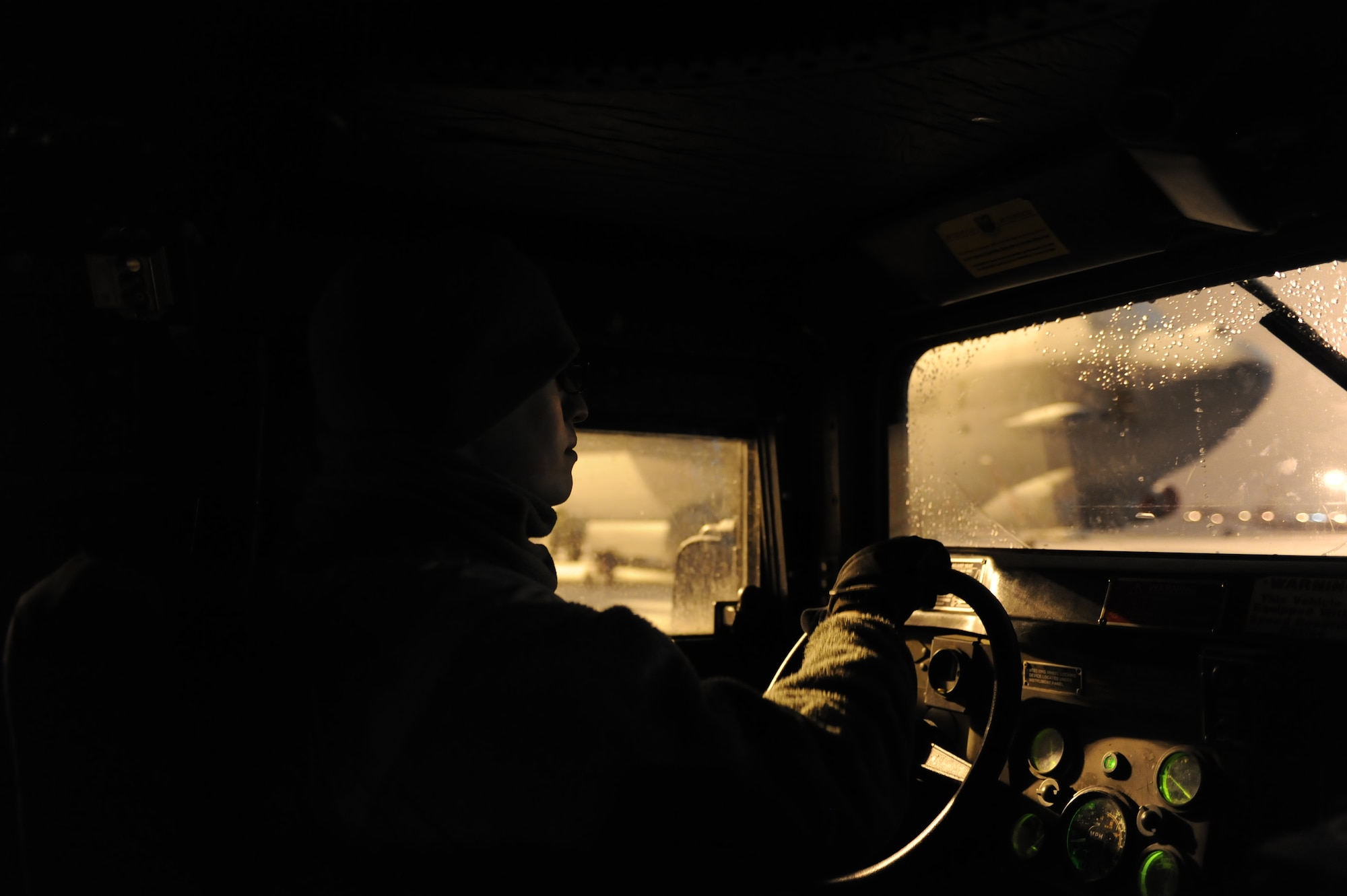 Senior Airman Sergio Romo, 5th Security Forces Squadron law enforcement patrolman, drives a Humvee past a B-52H Stratofortress on Minot Air Force Base, N.D., Jan. 24, 2015. While patrolling the flightline, Romo makes approximately 30 full circuits around it per night. (U.S. Air Force photo/Senior Airman Stephanie Morris)