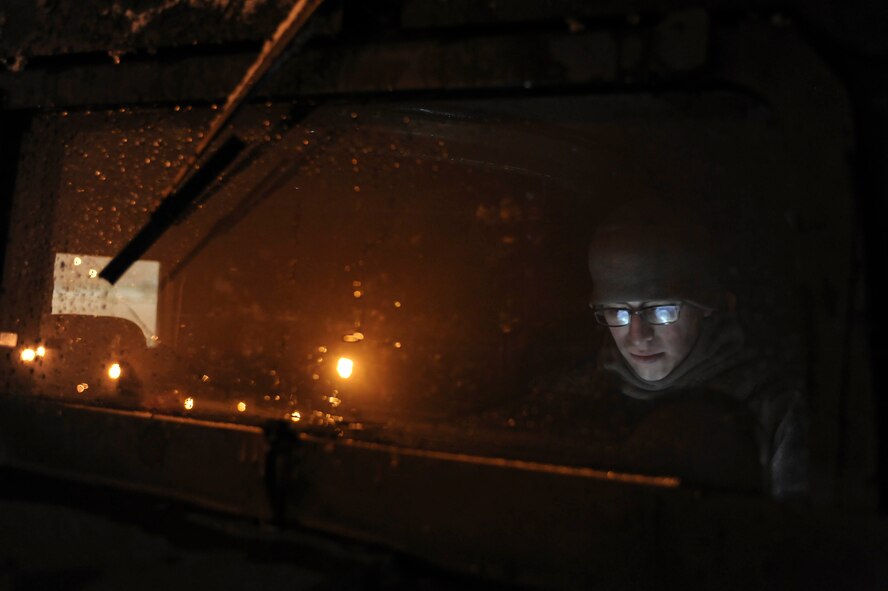 Senior Airman Sergio Romo, 5th Security Forces Squadron law enforcement patrolman, reads through work material inside of a Humvee on Minot Air Force Base, N.D., Jan. 24, 2015. Romo patrolled the flightline at night and kept a careful record of any activity as well as the location of aircraft. (U.S. Air Force photo/Senior Airman Stephanie Morris)