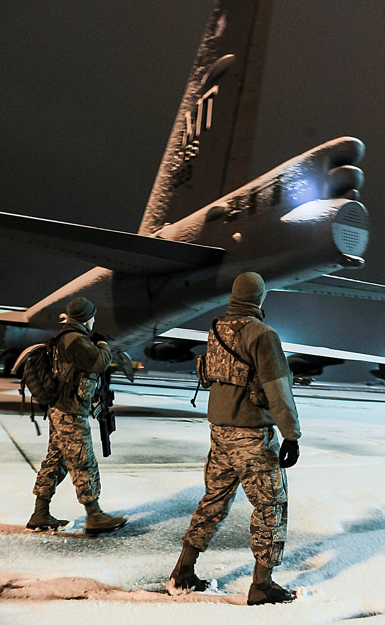(left) Airman 1st Class Zane Crady, 5th Security Forces Squadron response force team member, and (right) Senior Airman Sergio Romo, 5th SFS law enforcement patrolman, walk towards a B-52H Stratofortress on Minot Air Force Base, N.D., Jan. 24, 2015. Romo and Crady patrolled the flightline overnight searching for any suspicious activity. (U.S. Air Force photo/Senior Airman Stephanie Morris)