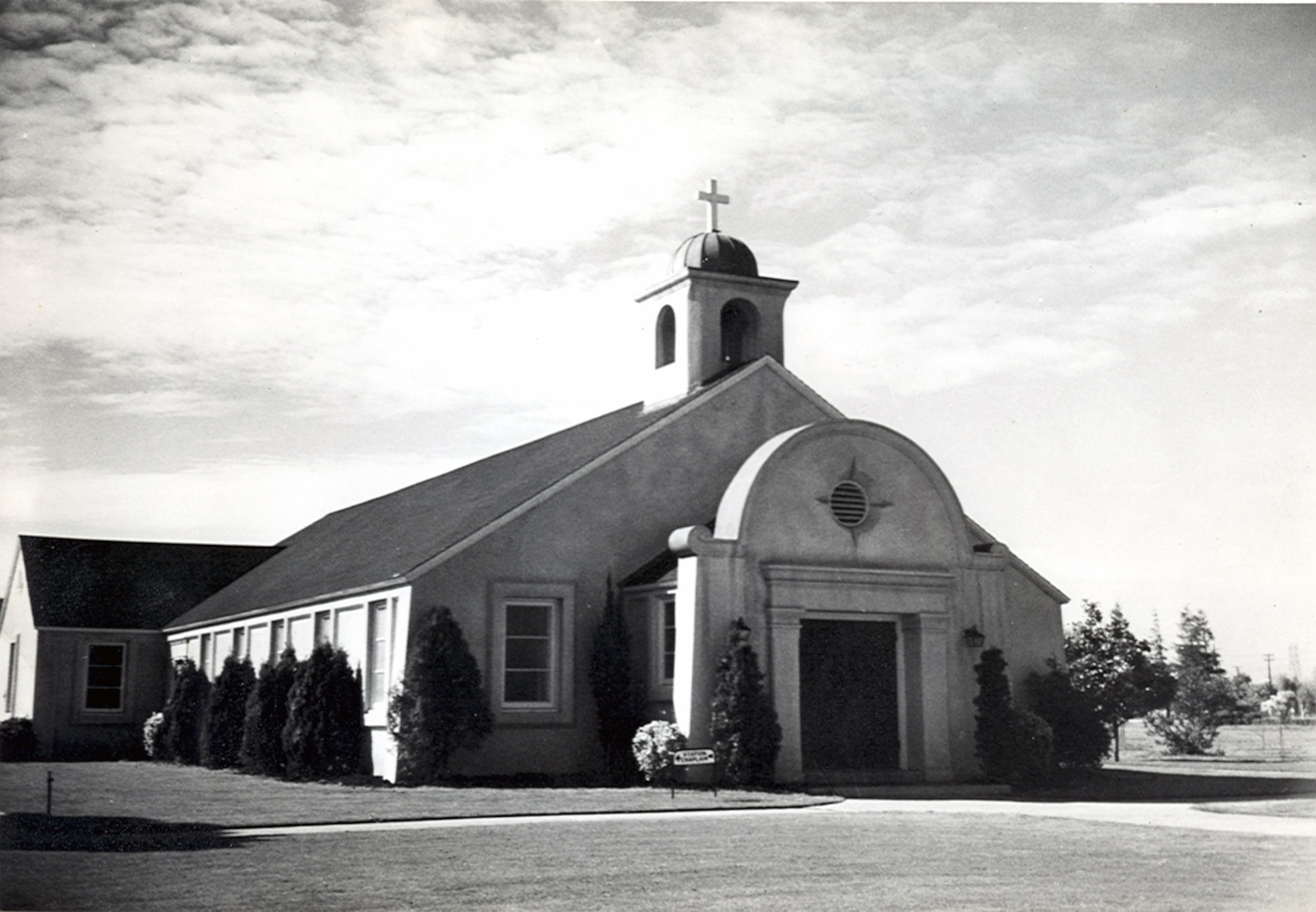 Black-and-white photograph of the Moffett Field Chapel. The chapel was constructed in 1945 and was modeled after the California Missions. The chapel owns a revolving altar which can be rotated to provide the appropriate settings for Protestant, Catholic, Jewish or non-denomination services. The chapel seats 200 people.  (Courtesy photo by the Sunnyvale Historical Society and Museum Association)