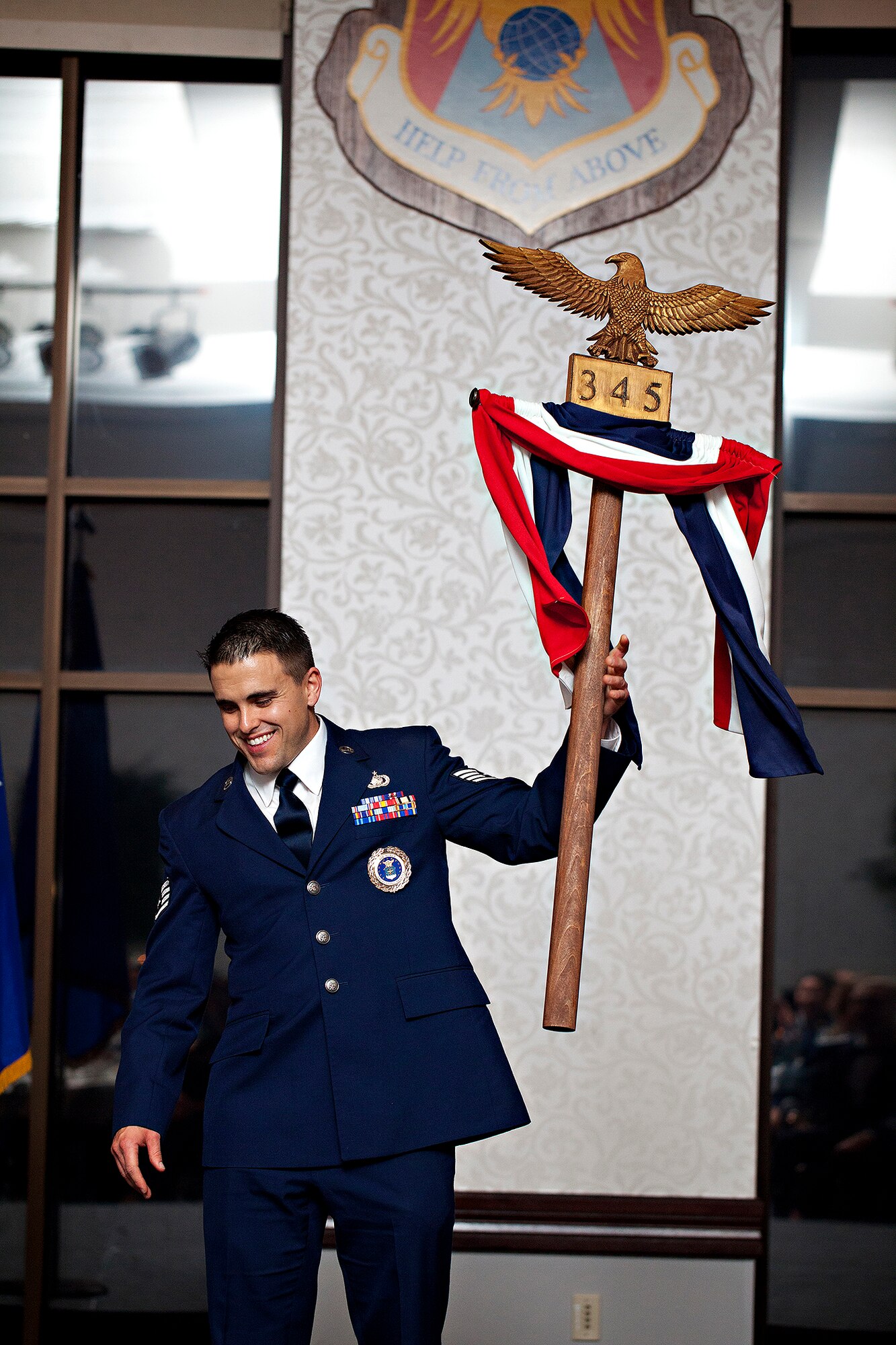 Staff Sgt. Tyler Martin holds the standard for the 345th Recruiting Squadron. The eagle was handcarved by Master Sgt. Raymond Boyd, A-Flight chief, who unveiled it at a quarterly training meeting in August 2014. He spent more than 40 hours constructing this work of art that will endure as the standard of the 345th RCS Screaming Eagles. (U.S. Air Force photo)
