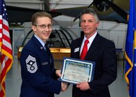 Chief Master Sgt. Brad E. Ferguson, 512th Airlift Wing command chief, presents a certificate of induction to Mark Brainard, Delaware Technical Community College president, as part of the Team Dover Induction Ceremony Feb. 7, 2015, at the Air Mobility Command Museum. The Honorary Commander Program began in 1992 at Dover Air Force Base, Del.,to foster relationships between civic and military leaders.  (U.S. Air Force photo/Airman 1st Class William Johnson)
