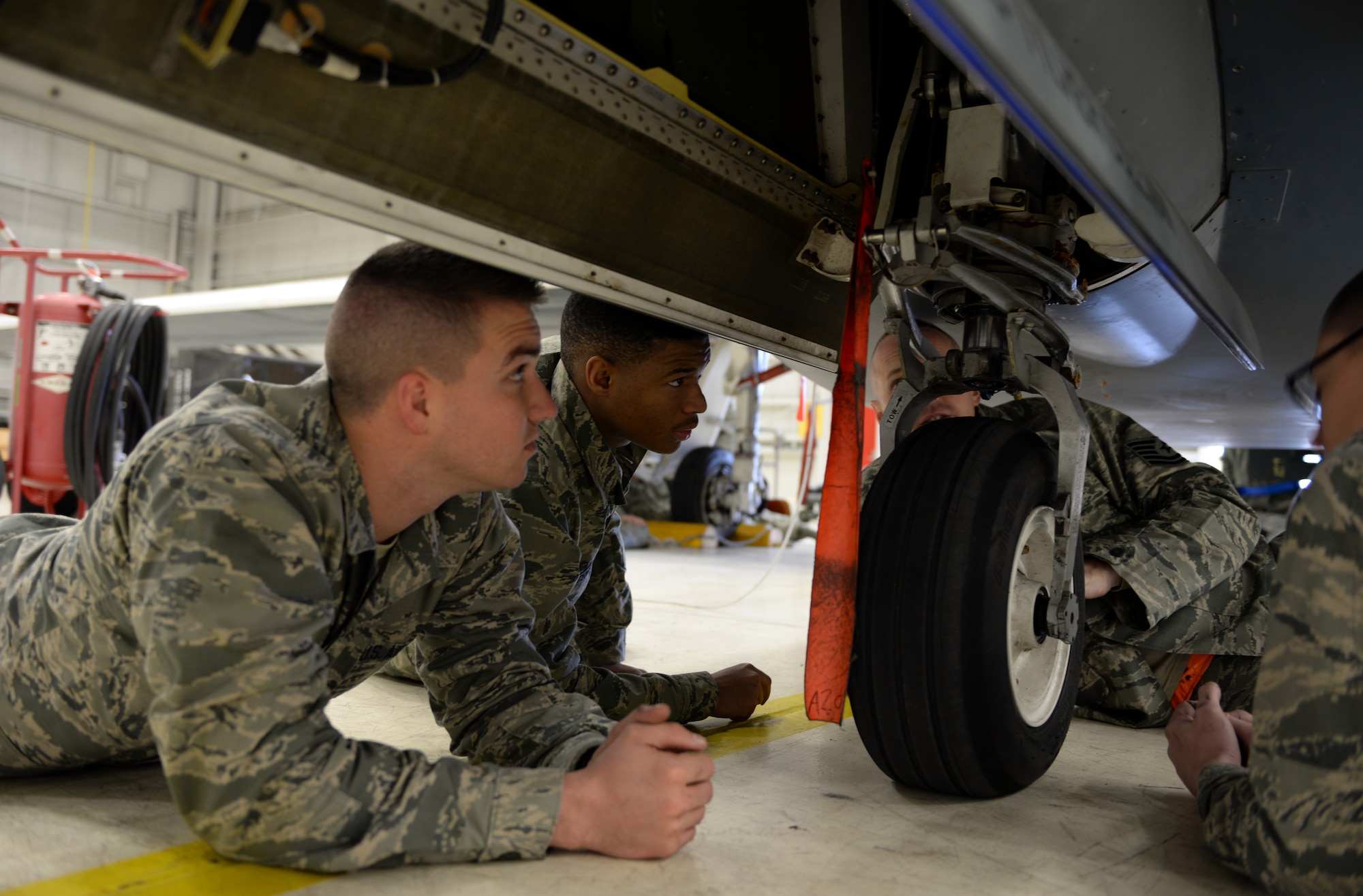Airmen with the 372nd Training Squadron Detachment 21, inspect the landing gear of a RQ-4 Global Hawk Jan. 20, 2015, at Beale Air Force Base, Calif. The Airmen are the first students to attend the RQ-4 remotely piloted aircraft maintenance course taught at Beale. (U.S. Air Force photo by Senior Airman Bobby Cummings/Released)