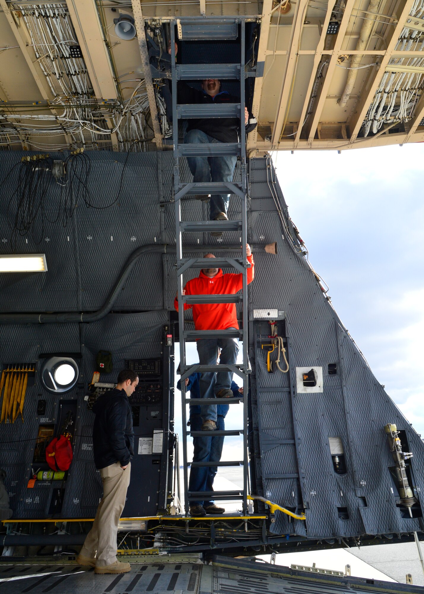 Civilian contractors climb stairs to the second level of a C-5M Super Galaxy during a tour of the aircraft Jan. 30, 2015, at Dover Air Force Base, Del. The contractors will begin renovating runway 01-19 this month and operations are expected to last through June 2016. (U.S. Air Force photo/Airman 1st Class William Johnson)