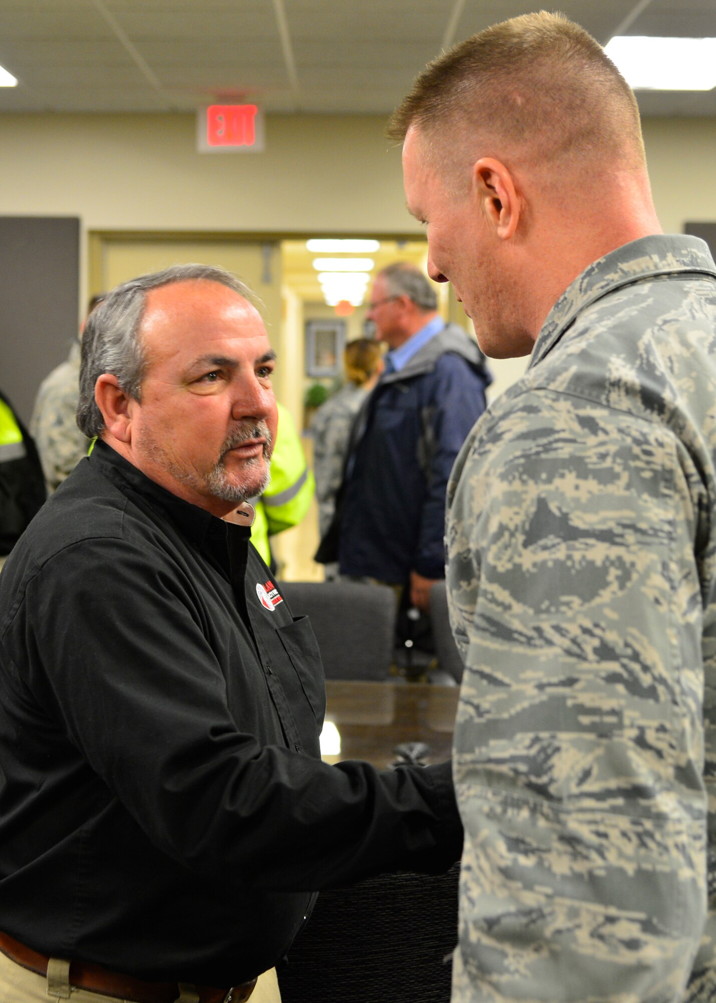 Col. Michael Grismer, 436th Airlift Wing commander, shakes hands with Lamar Woods, Atlantic Electric superintendent, following a briefing Jan. 30, 2015, at Dover Air Force Base, Del. Contractors who are conducting runway renovation operations took a short tour of the base and C-5M Super Galaxy and C-17A Globemaster III aircraft following the briefing. (U.S. Air Force photo/Airman 1st Class William Johnson)