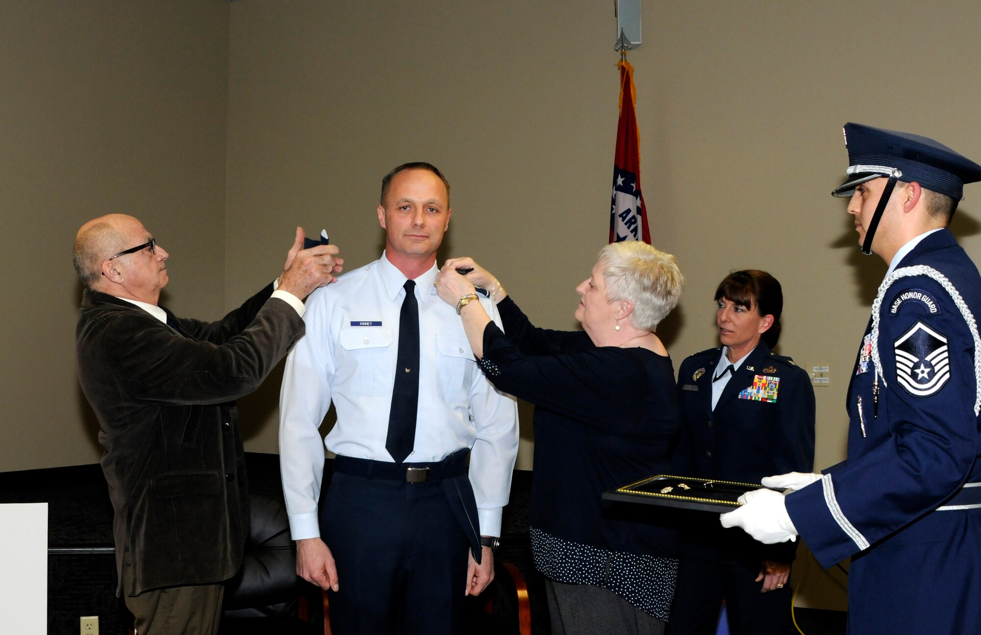 Col. Robert I. Kinney, 188th Intelligence, Surveillance and Reconnaissance Group commander, stands at attention as and his parents, retired Master Sgt. David Kinney and Alice Kinney, pin on the rank of colonel Feb. 8, 2015, during a formal promotion ceremony held at Ebbing Air National Guard Base, Fort Smith, Ark. Robert Kinney joined the Air National Guard in 1990 and has spent time in various positions throughout the country in the intelligence career field. The ceremony was presided by his wife, Col. Paige Kinney, director of ISR at the Continental U.S. North American Aerospace Defense Command Region, 1st Air Force, Air Forces Northern, Tyndall Air Force Base, Fla. Master Sgt. Michael Aponte, 288th Operations Support Squadron member, was the proffer during the ceremony. (U.S. Air National Guard photo by Staff Sgt. Hannah Dickerson/released)
