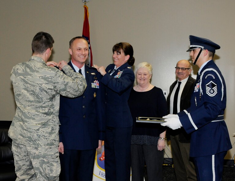 Col. Robert I. Kinney, 188th Intelligence, Surveillance and Reconnaissance Group commander, stands at attention as Col. Brandon Beightol, National Guard Bureau A2 deputy director ISR, and Col. Paige Kinney pin on the rank of colonel as Robert Kinney’s parents, retired Master Sgt. David Kinney and Alice Kinney observe, Feb. 8, 2015, during a formal promotion ceremony held at Ebbing Air National Guard Base, Fort Smith, Ark. Robert Kinney joined the Air National Guard in 1990 and has spent time in various positions throughout the country  in the intelligence career field. The ceremony was presided by Robert Kinney’s wife, Paige Kinney, director of ISR at the Continental U.S. North American Aerospace Defense Command Region, 1st Air Force, Air Forces Northern, Tyndall Air Force Base, Fla. Master Sgt. Michael Aponte, 288th Operations Support Squadron member, was the proffer during the ceremony. (U.S. Air National Guard photo by Staff Sgt. Hannah Dickerson/released)