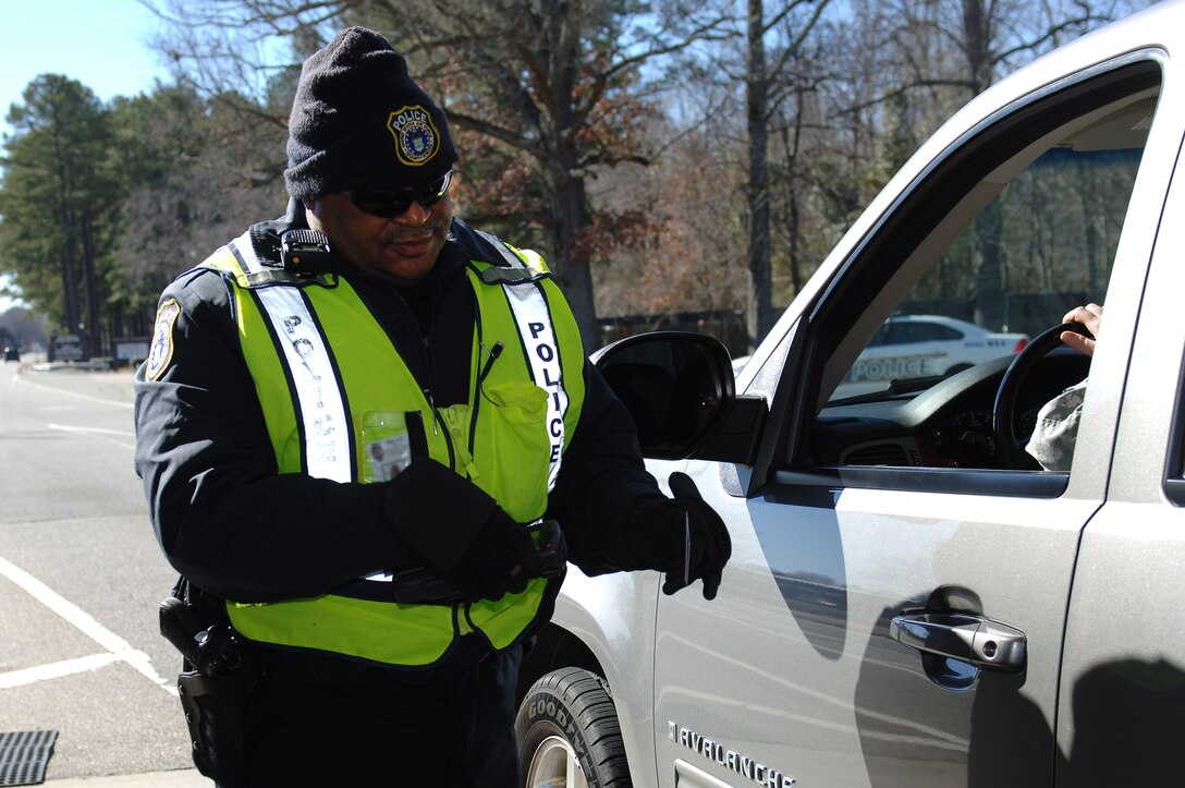 David Head, 733rd Security Forces Squadron police officer, scans a Common Access Card into the Defense Biometric Identification System at Fort Eustis, Va., Feb. 3, 2015. Since using the system, Joint Base Langley-Eustis has seen an increase in the denial of base access to unauthorized individuals. (U.S. Air Force photo by Staff Sgt. Teresa J. Cleveland/Released)