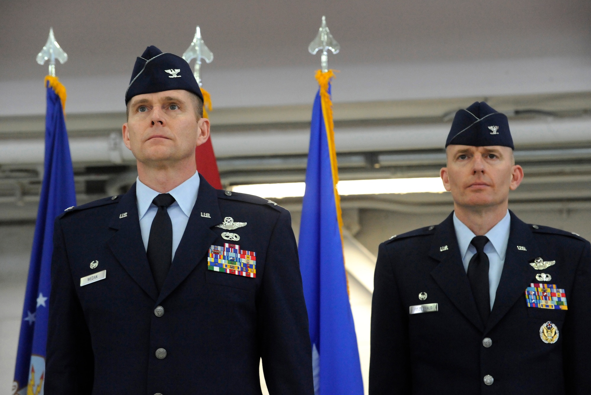U.S. Air Force Col. Richard W. Wedan, outgoing commander 142nd Fighter Wing, left, and Col. Paul T. Fitzgerald, incoming commander 142nd Fighter Wing, right, stand at attention as orders for the citation for The Air Force Legion of Merit Medal are read and presented to Wedan during the Change of Command ceremony held Feb. 7, 2015, Portland Air National Guard Base, Ore. (U.S. Air National Guard photo by Tech. Sgt. John Hughel, 142nd Fighter Wing Public Affairs)