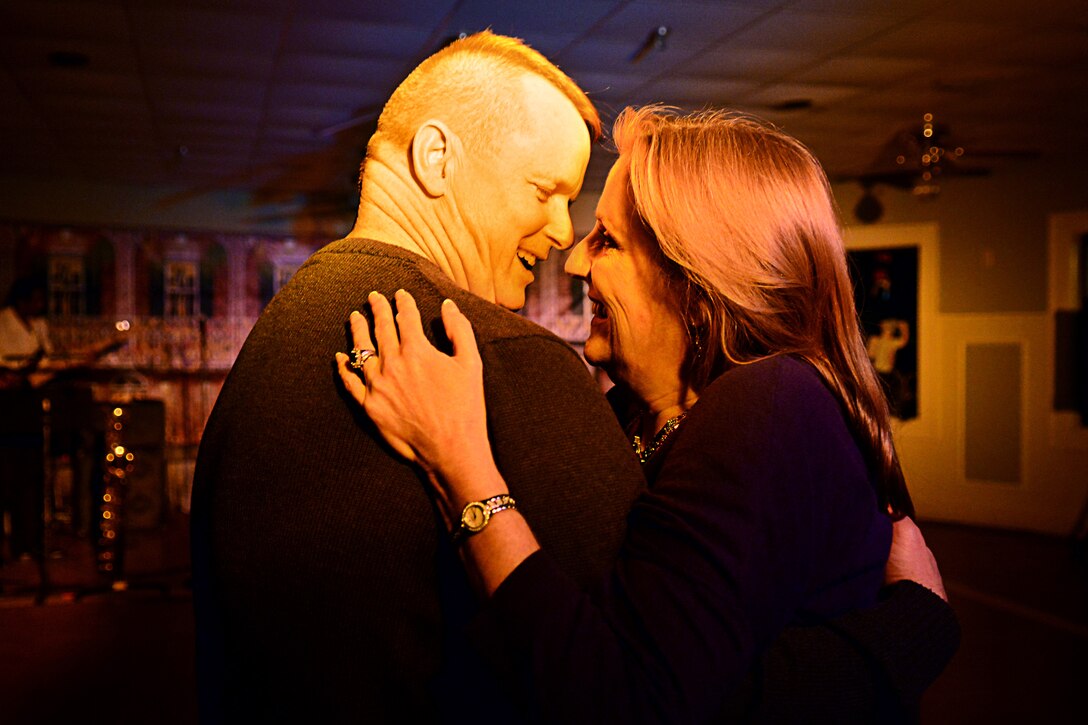 U.S. Army Sgt. Major Dennis Woods, Initial Military Training command sergeant major, dances with his wife, Leigh, during the Mardi Gras celebration at Fort Eustis, Va., Feb. 6, 2015. All members of the Joint Base Langley-Eustis and local community were invited to celebrate at the Fort Eustis club with live music, casino games, food and drinks. (U.S. Air Force photo illustration by Airman 1st Class Devin Scott Michaels/Released)