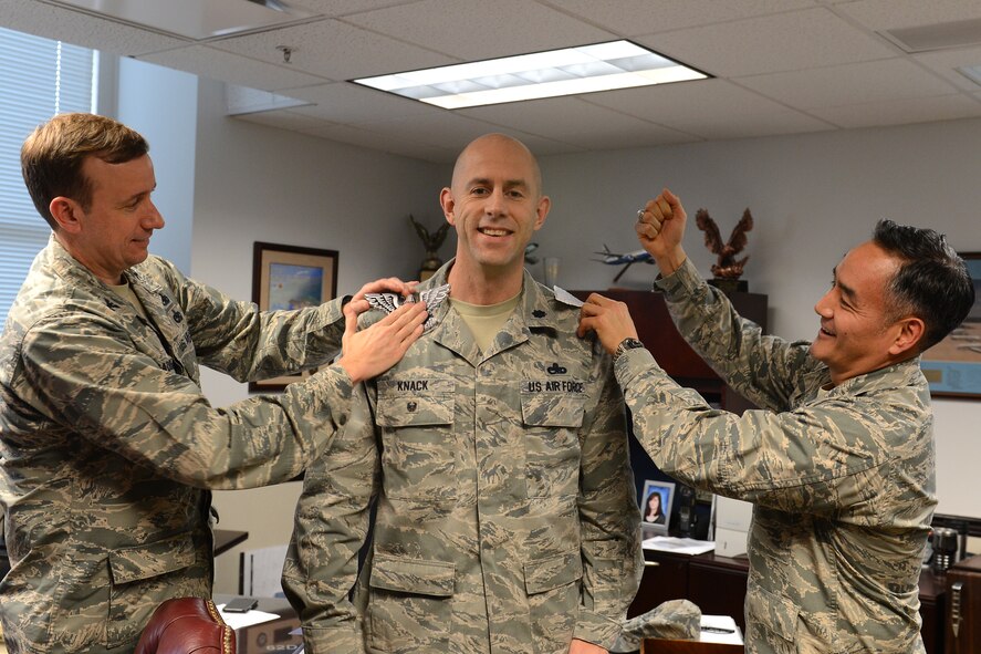 Lt. Col. Tyler Knack(center), 62nd Maintenance Group deputy commander, receives notification of his selection to O-6 from Col. David Kumashiro(right), 62nd Airlift Wing commander and Col. Craig Gaddis, 62nd Operations Group commander, Feb. 9, 2015 at Joint Base Lewis-McChord, Wash. ( U.S. Air Force phot \ Staff Sgt. Tim Chacon)