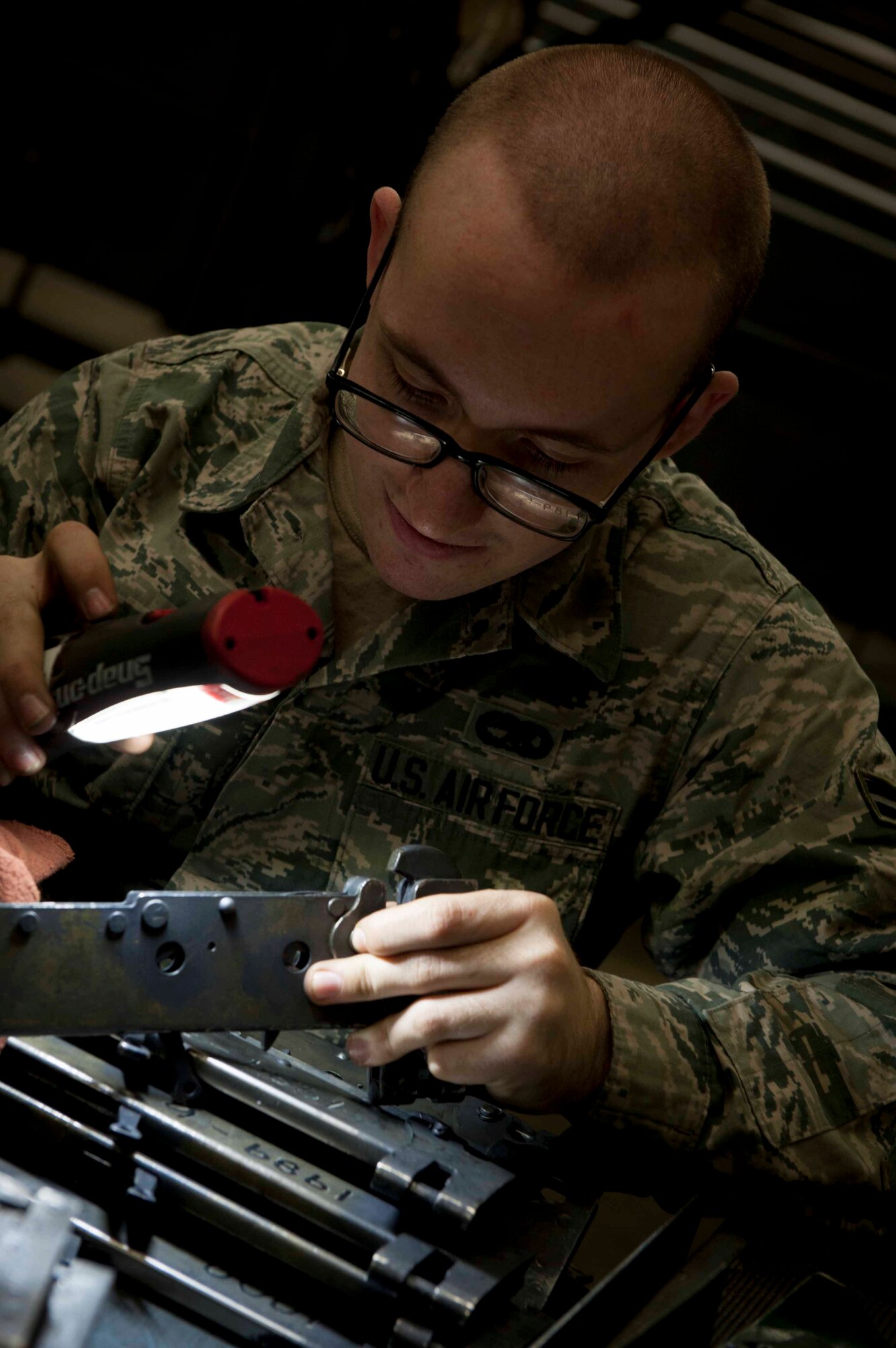 Airman 1st Class Cody Bryson, 5th Munitions Squadron armament team member, inspects a B-11 shackle on Minot Air Force Base, N.D., Feb. 3, 2015. B-11 shackles are used to hold weapons in place on bomb racks. While inspecting the shackles, he used small bore brushes to remove rust and debris to ensure the pieces are in proper working order (U.S. Air Force photo/Airman 1st Class Sahara L. Fales)